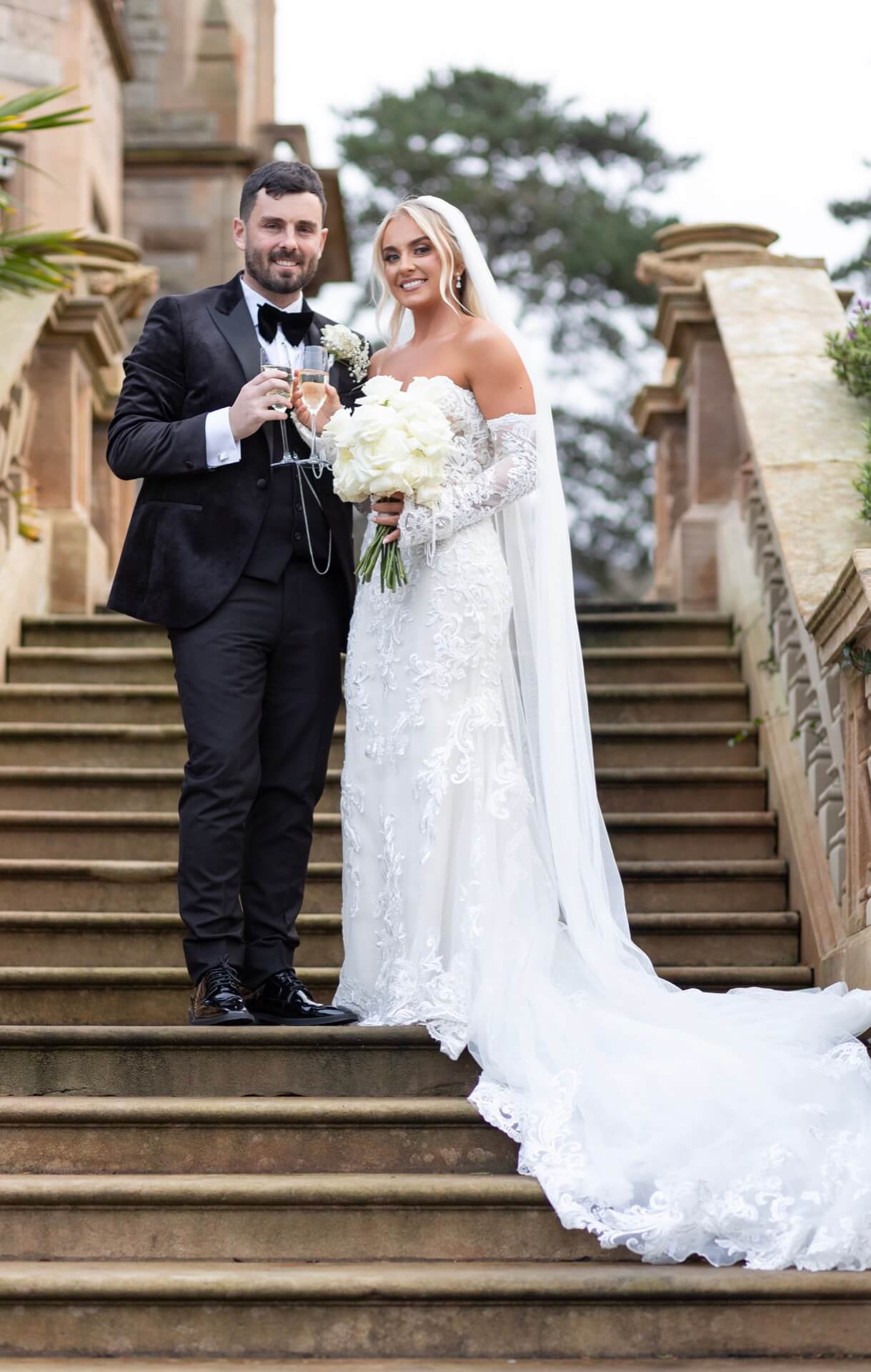 Wedding couple on grand stone steps Culloden Estate