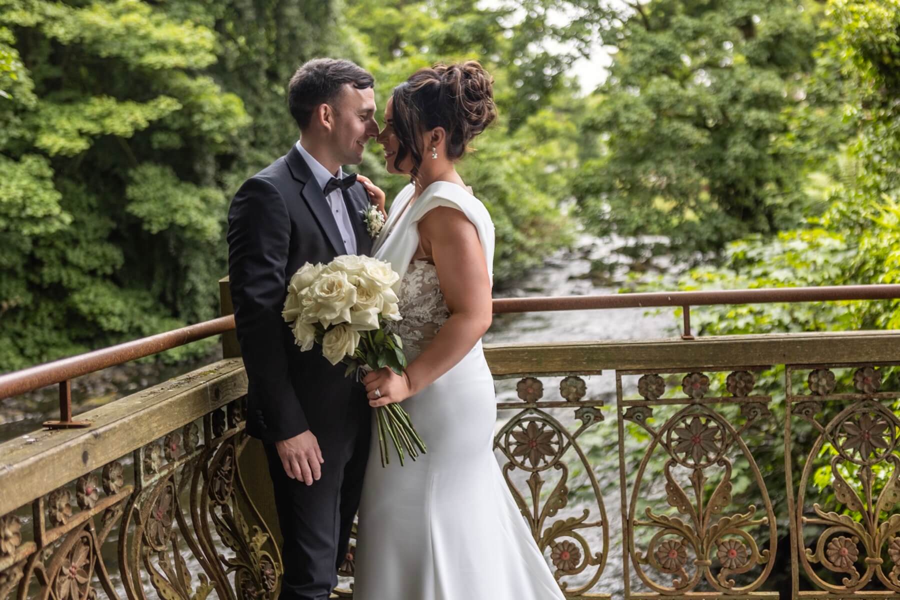 Wedding couple on ornate bridge Galgorm Resort Spa Northern Ireland wedding venue photography