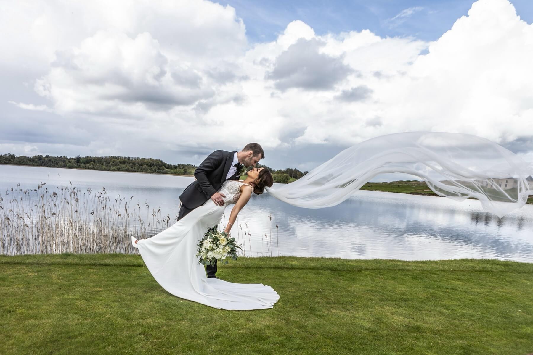 Wedding couple by Lough Erne veil flying